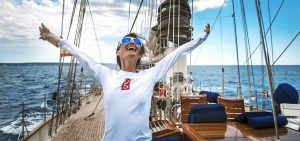 Happy woman on the deck of a luxury sailing yacht